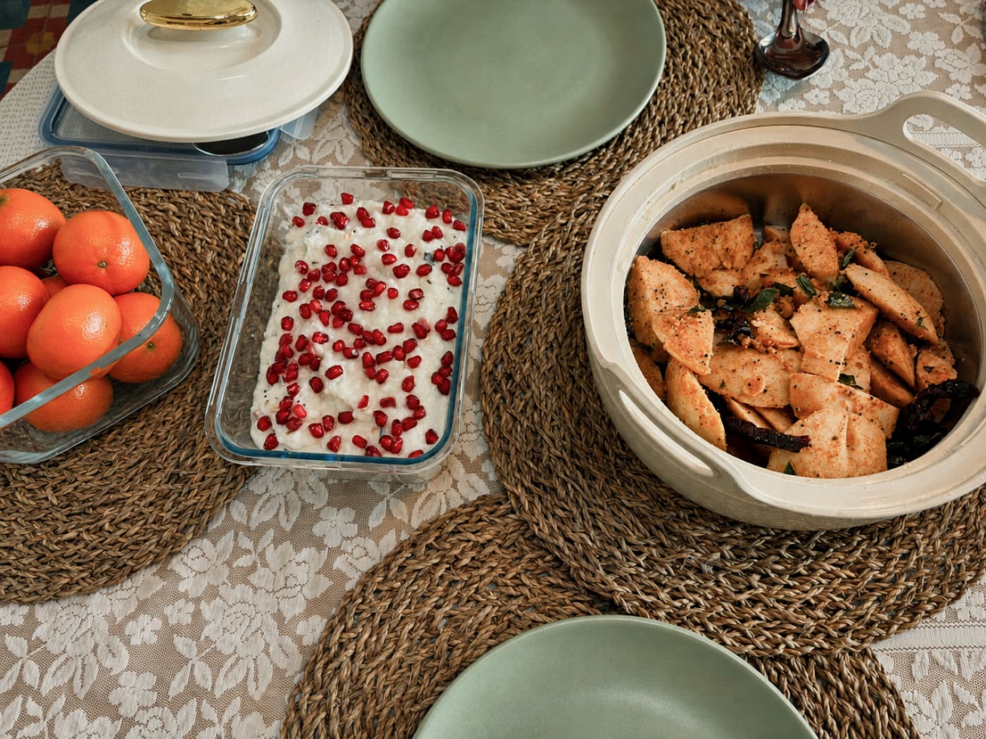 A table laid with oranges, pomegranate curd and a dish of roasted vegetables