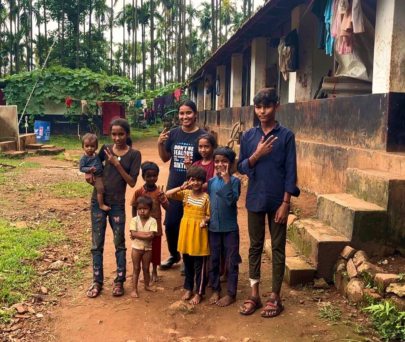 Children and young people standing together outside the workers’ quarters