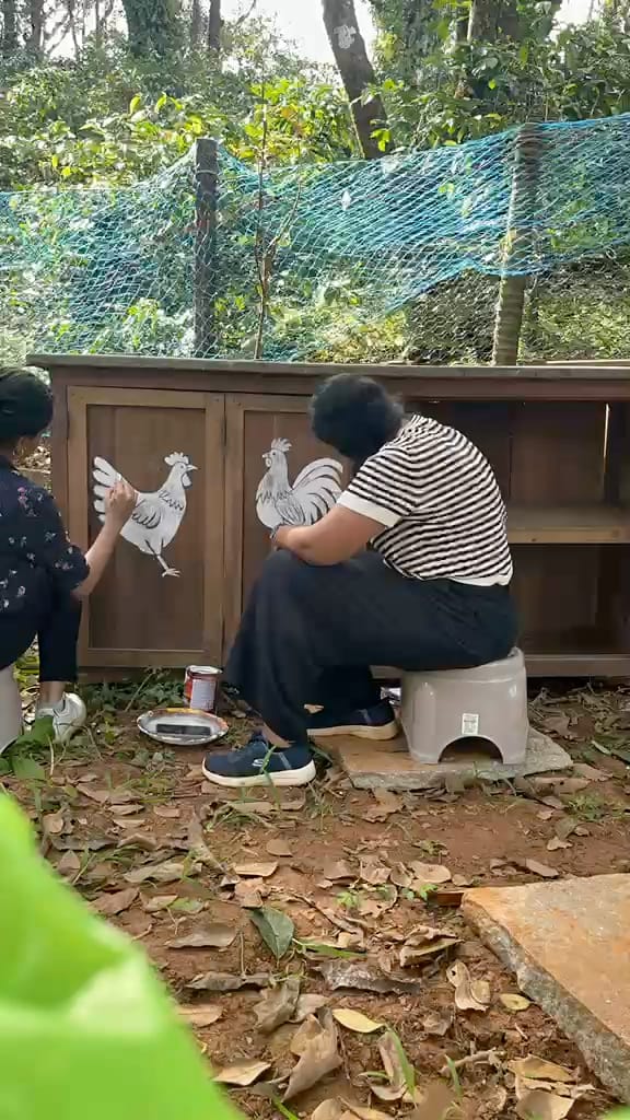 Painting hens onto the doors of the chicken coop