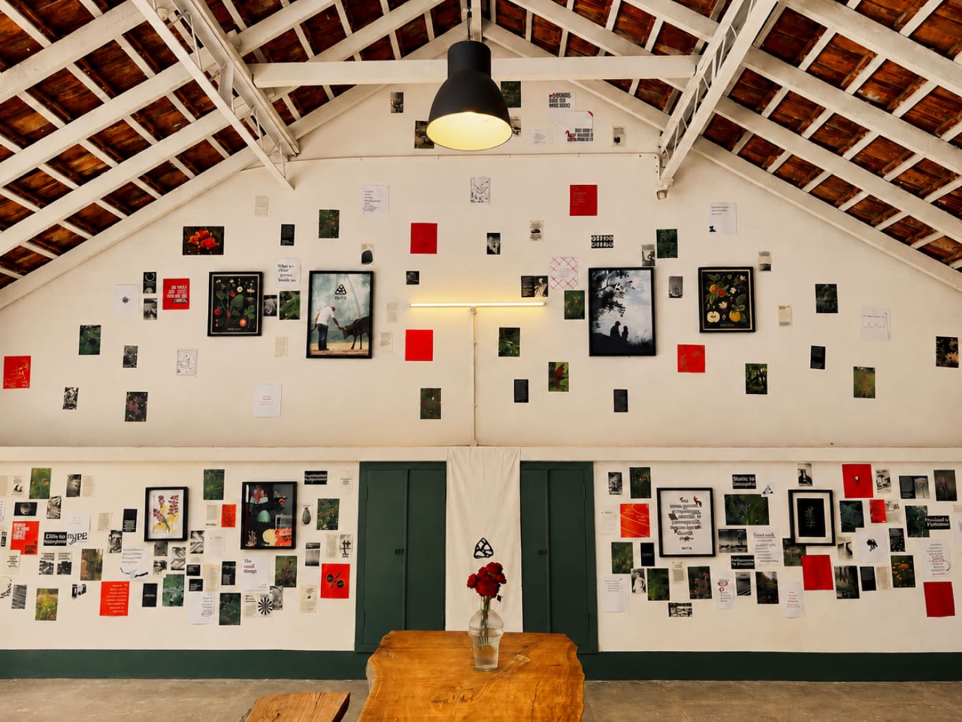 The studio wall hung with small framed and pinned works