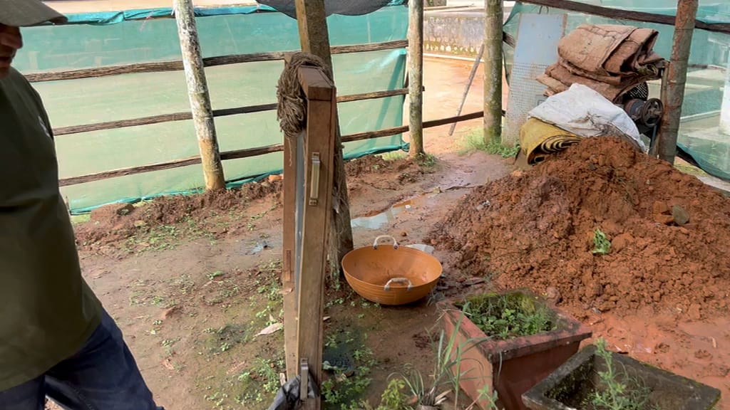 Sadanand at work by the compost beds under a shade net