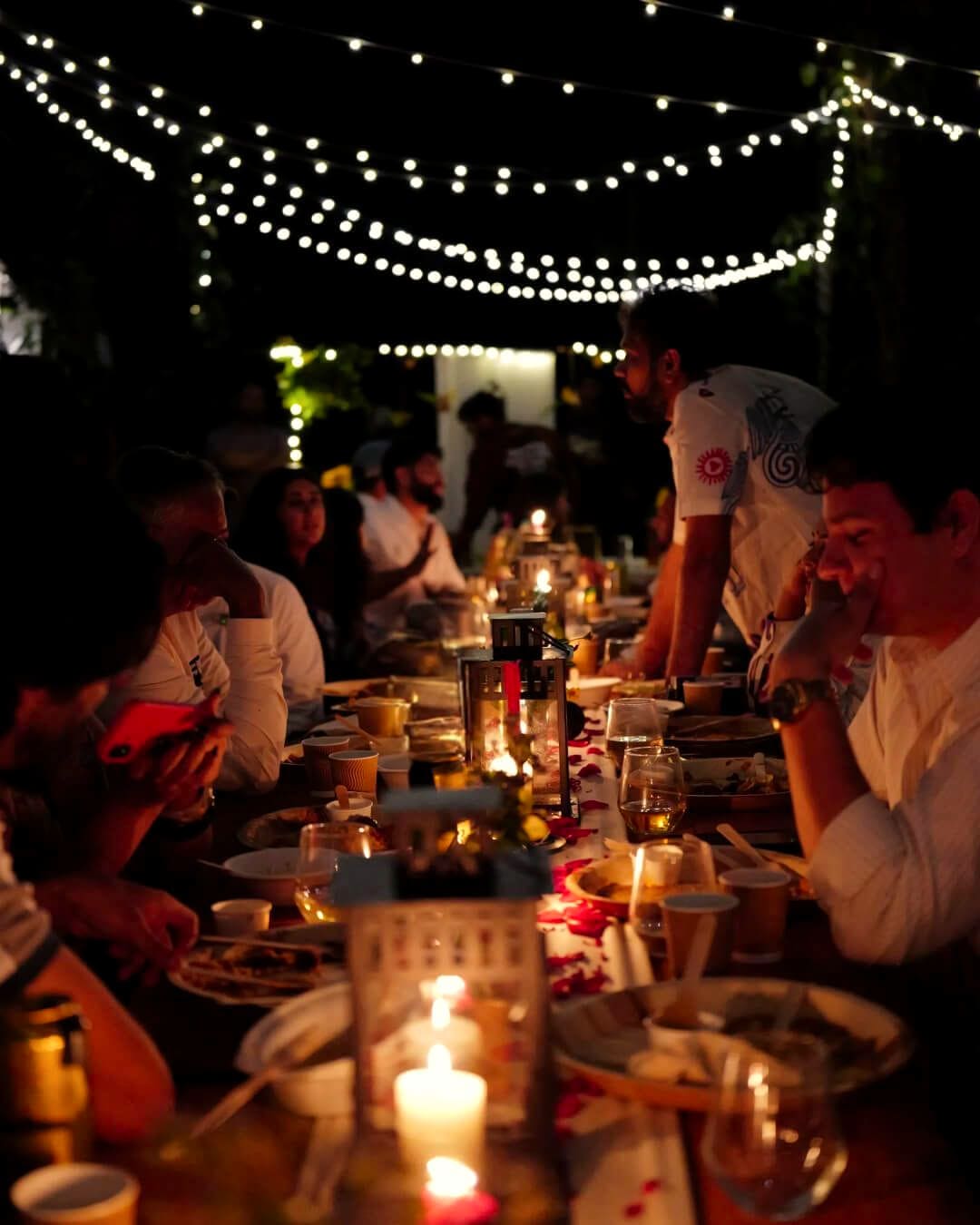 Guests at the long table under the string lights