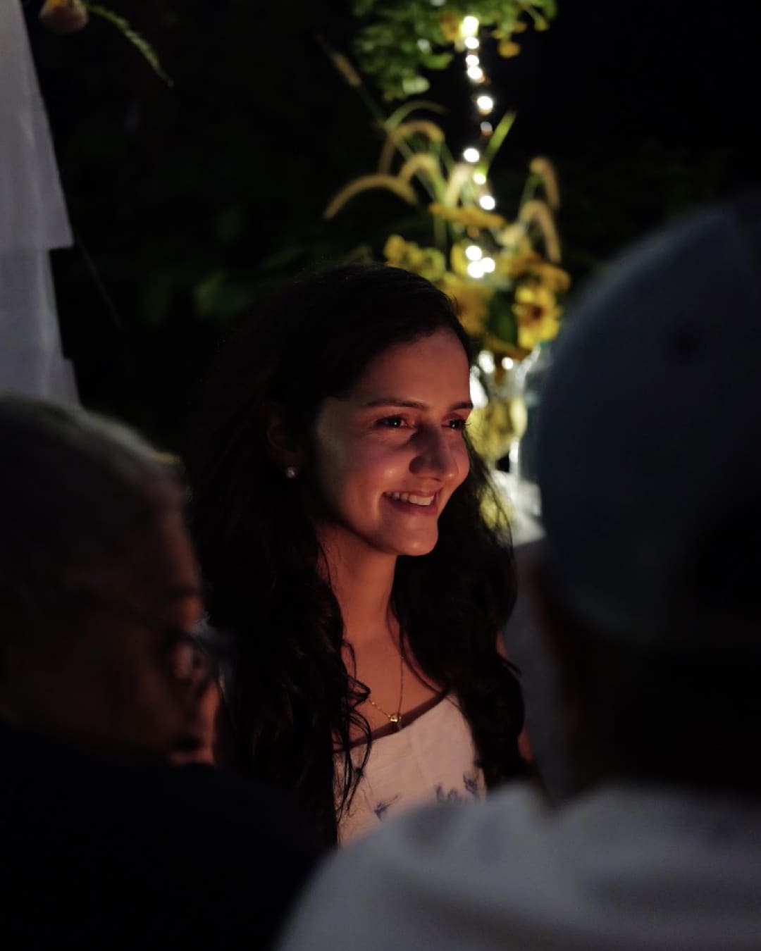 A guest smiling in the candlelight at the dinner table