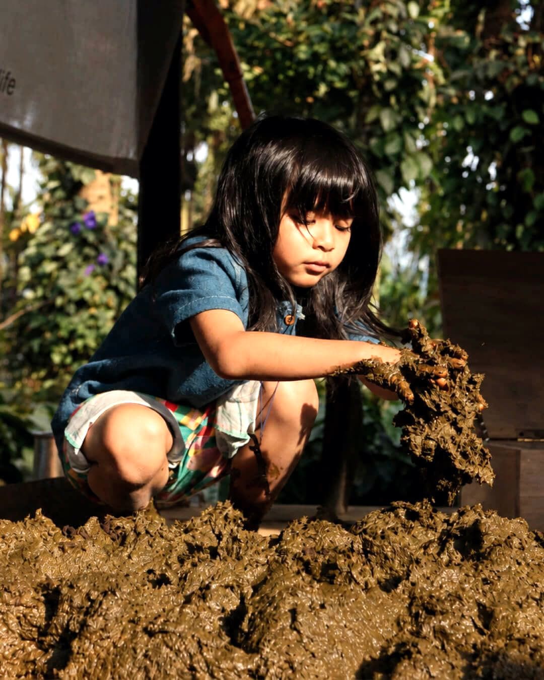 A child reaching into the compost