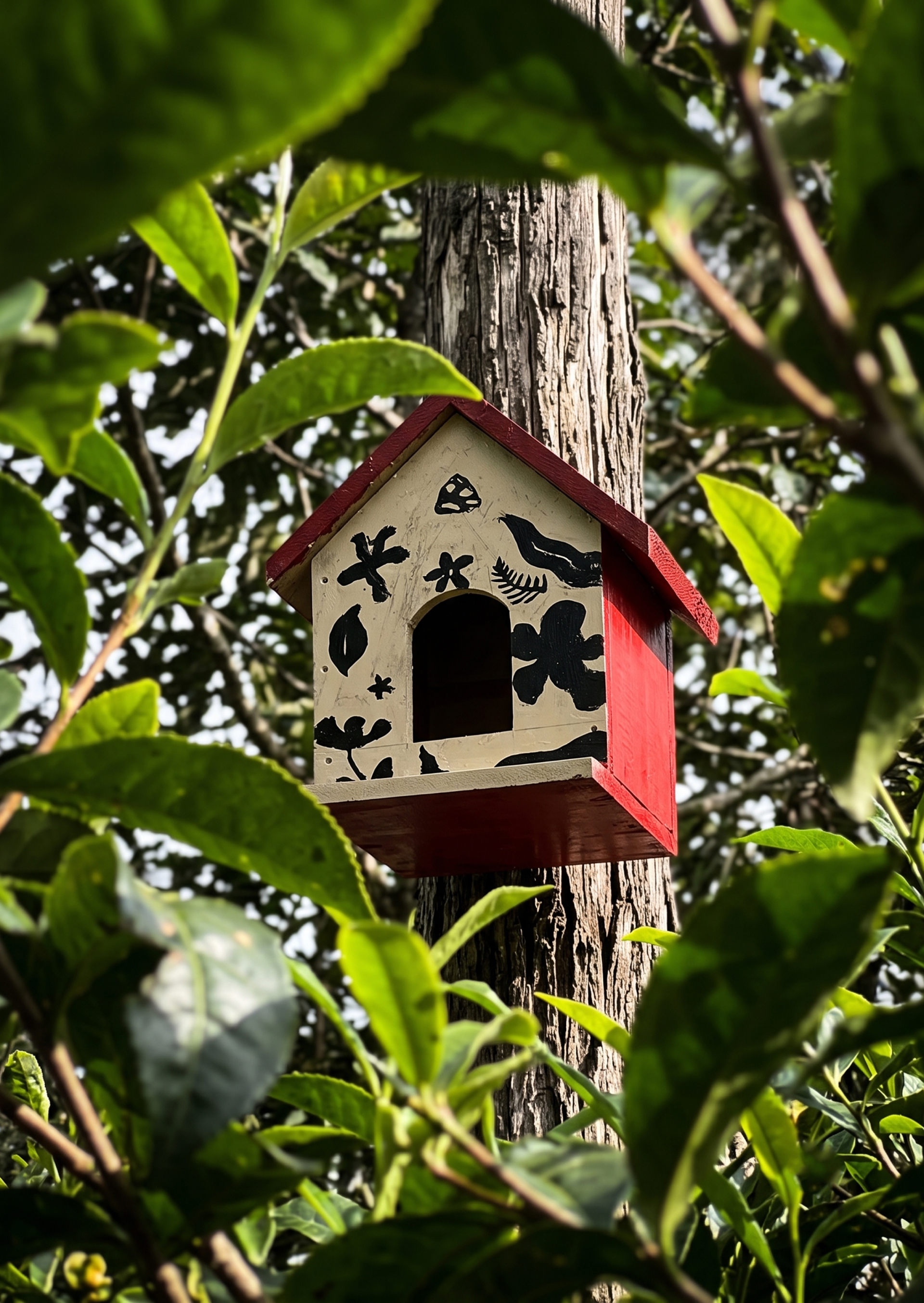 A hand-painted birdhouse mounted in a tree on the estate